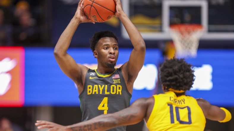 Jan 18, 2022; Morgantown, West Virginia, USA; Baylor Bears guard LJ Cryer (4) looks to pass while defended by West Virginia Mountaineers guard Malik Curry (10) during the first half at WVU Coliseum. Mandatory Credit: Ben Queen-USA TODAY Sports