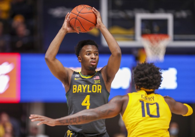 Jan 18, 2022; Morgantown, West Virginia, USA; Baylor Bears guard LJ Cryer (4) looks to pass while defended by West Virginia Mountaineers guard Malik Curry (10) during the first half at WVU Coliseum. Mandatory Credit: Ben Queen-USA TODAY Sports