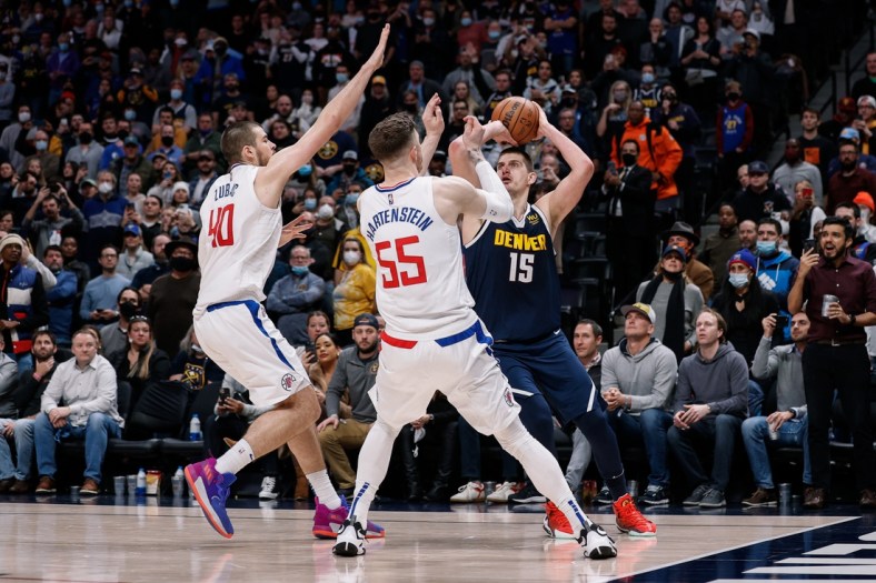 Jan 19, 2022; Denver, Colorado, USA; Denver Nuggets center Nikola Jokic (15) looks to the shoot the ball as Los Angeles Clippers center Isaiah Hartenstein (55) and center Ivica Zubac (40) defend in the fourth quarter at Ball Arena. Mandatory Credit: Isaiah J. Downing-USA TODAY Sports