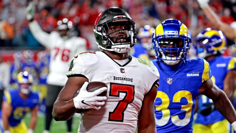 Jan 23, 2022; Tampa, Florida, USA; Tampa Bay Buccaneers running back Leonard Fournette (7) run the ball for a touchdown  against Los Angeles Rams safety Nick Scott (33)  in a NFC Divisional playoff football game at Raymond James Stadium. Mandatory Credit: Matt Pendleton-USA TODAY Sports