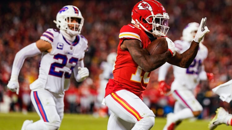 Jan 23, 2022; Kansas City, Missouri, USA; Kansas City Chiefs wide receiver Tyreek Hill (10) runs the ball for a touchdown past Buffalo Bills safety Micah Hyde (23) during the second half in a AFC Divisional playoff football game at GEHA Field at Arrowhead Stadium. Mandatory Credit: Jay Biggerstaff-USA TODAY Sports