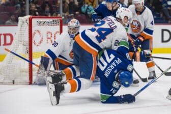 Feb 9, 2022; Vancouver, British Columbia, CAN; New York Islanders defenseman Scott Mayfield (24) checks Vancouver Canucks forward Tanner Pearson (70) in the third period at Rogers Arena. New York won 6-3. Mandatory Credit: Bob Frid-USA TODAY Sports