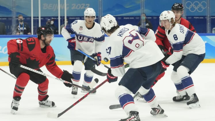 Feb 12, 2022; Beijing, China; Team Canada forward David Desharnais (51) fights for the puck with Team USA forward Matty Beniers (10), forward Matt Knies (67), and defender Jake Sanderson (8) during the first period in the men's ice hockey preliminary round of the Beijing 2022 Olympic Winter Games at National Indoor Stadium. Mandatory Credit: Rob Schumacher-USA TODAY Sports