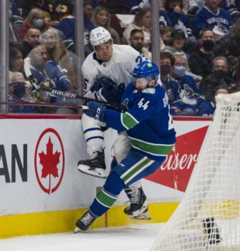 Feb 12, 2022; Vancouver, British Columbia, CAN; Vancouver Canucks defenseman Kyle Burroughs (44) checks Toronto Maple Leafs forward Ondrej Kase (25) in the second period at Rogers Arena. Mandatory Credit: Bob Frid-USA TODAY Sports