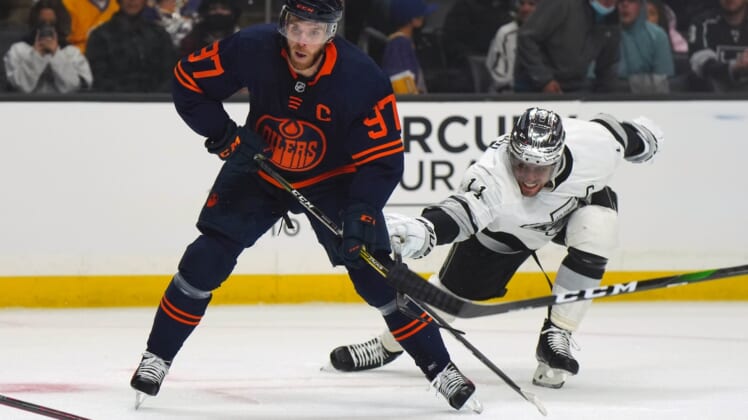 Feb 15, 2022; Los Angeles, California, USA; Edmonton Oilers center Connor McDavid (97) and LA Kings center Anze Kopitar (11) battle for the puck in the first period at Crypto.com Arena. Mandatory Credit: Kirby Lee-USA TODAY Sports
