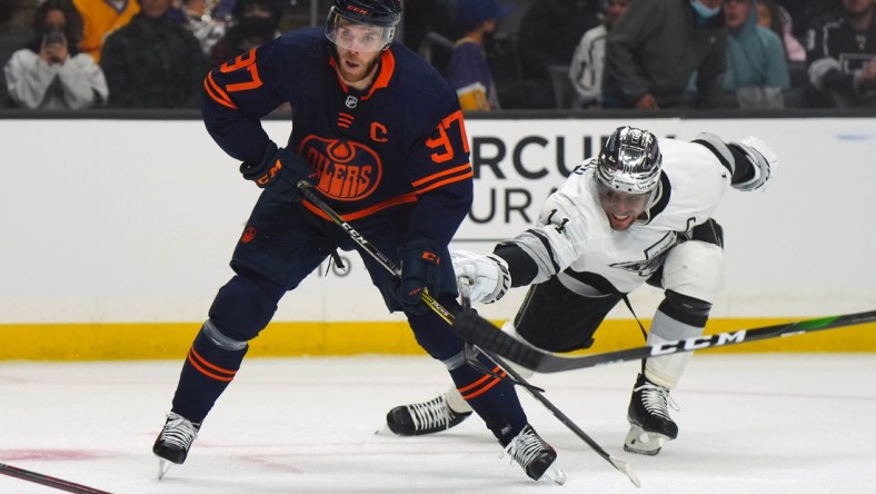 Feb 15, 2022; Los Angeles, California, USA; Edmonton Oilers center Connor McDavid (97) and LA Kings center Anze Kopitar (11) battle for the puck in the first period at Crypto.com Arena. Mandatory Credit: Kirby Lee-USA TODAY Sports