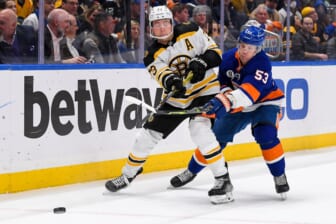 Feb 17, 2022; Elmont, New York, USA;  Boston Bruins defenseman Charlie McAvoy (73) attempts to pass defended by New York Islanders center Casey Cizikas (53) during the second period at UBS Arena. Mandatory Credit: Dennis Schneidler-USA TODAY Sports