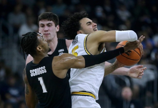 Providence Friar Justin Minaya struggles to keep the ball from Xavier defenders Paul Scruggs and Zach Freemantle against a Musketeer press.