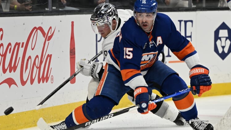 Feb 26, 2022; Los Angeles, California, USA;  New York Islanders right wing Cal Clutterbuck (15) and Los Angeles Kings right wing Carl Grundstrom (91) battle for the puck in the third period at Crypto.com Arena. Mandatory Credit: Jayne Kamin-Oncea-USA TODAY Sports