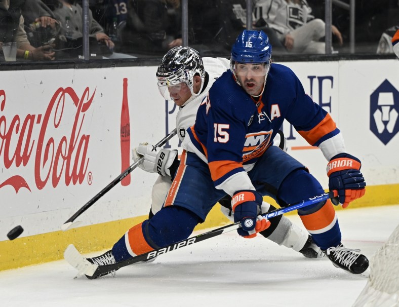 Feb 26, 2022; Los Angeles, California, USA;  New York Islanders right wing Cal Clutterbuck (15) and Los Angeles Kings right wing Carl Grundstrom (91) battle for the puck in the third period at Crypto.com Arena. Mandatory Credit: Jayne Kamin-Oncea-USA TODAY Sports