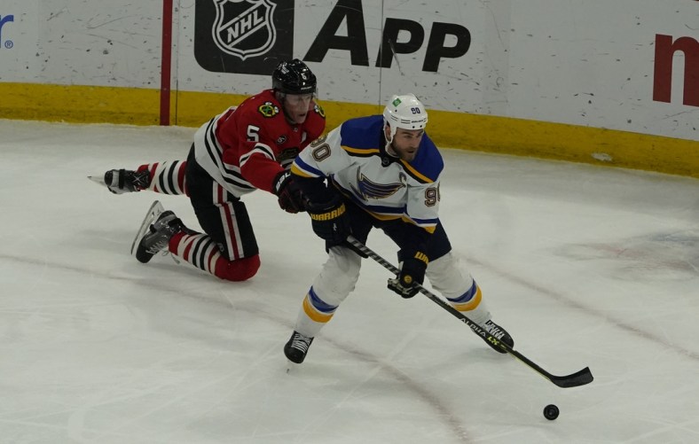 Feb 27, 2022; Chicago, Illinois, USA; Chicago Blackhawks defenseman Connor Murphy (5) defends St. Louis Blues center Ryan O'Reilly (90) during the first period at United Center. Mandatory Credit: David Banks-USA TODAY Sports