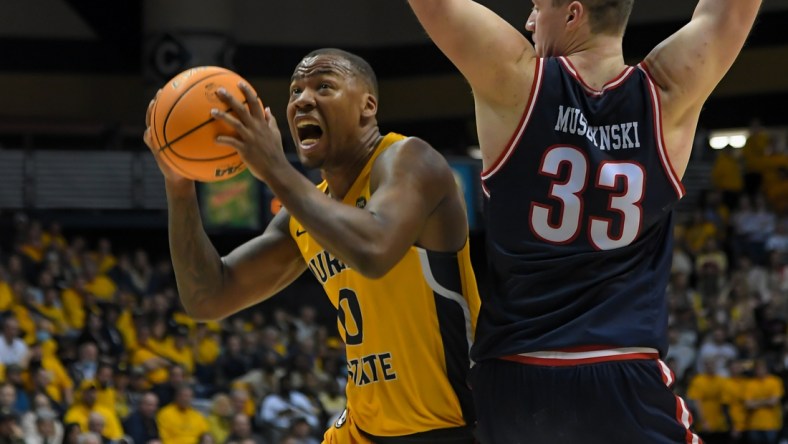 Feb 24, 2022; Murray, Kentucky, USA;  Murray State Racers forward KJ Williams (0) drives past Belmont Bruins center Nick Muszynski (33) during the second half at CFSB Center. Mandatory Credit: Steve Roberts-USA TODAY Sports