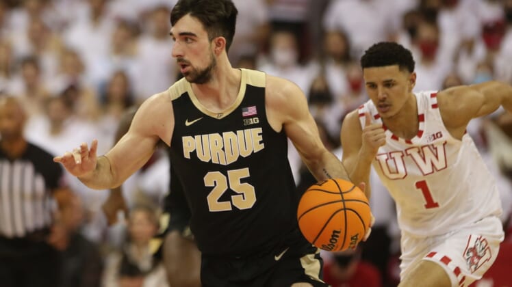 Mar 1, 2022; Madison, Wisconsin, USA; Purdue Boilermakers guard Ethan Morton (25) brings the ball up the floor as Wisconsin Badgers guard Johnny Davis (1) follows during the first half at the Kohl Center. Mandatory Credit: Mary Langenfeld-USA TODAY Sports