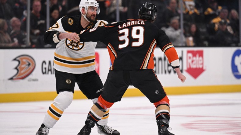 Mar 1, 2022; Anaheim, California, USA; Boston Bruins left wing Nick Foligno (17) fights Anaheim Ducks center Sam Carrick (39) during the first period at Honda Center. Mandatory Credit: Orlando Ramirez-USA TODAY Sports