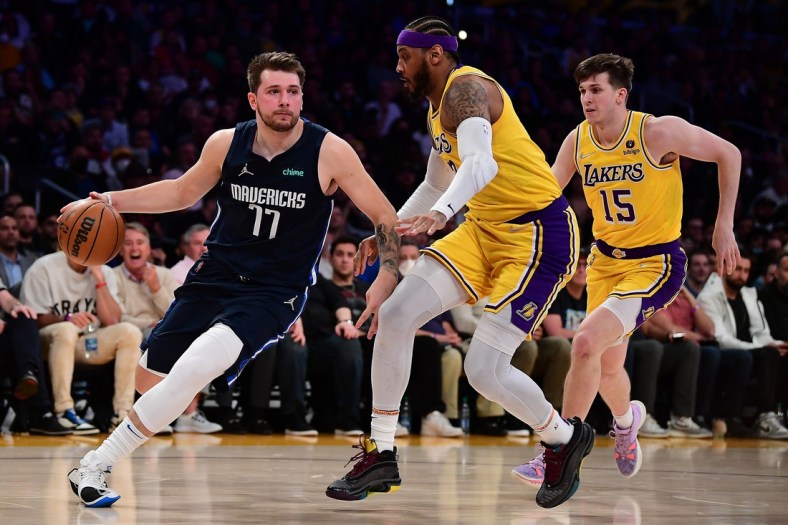 Mar 1, 2022; Los Angeles, California, USA; Dallas Mavericks guard Luka Doncic (77) moves to the basket against Los Angeles Lakers forward Carmelo Anthony (7) and guard Austin Reaves (15) during the first half at Crypto.com Arena. Mandatory Credit: Gary A. Vasquez-USA TODAY Sports