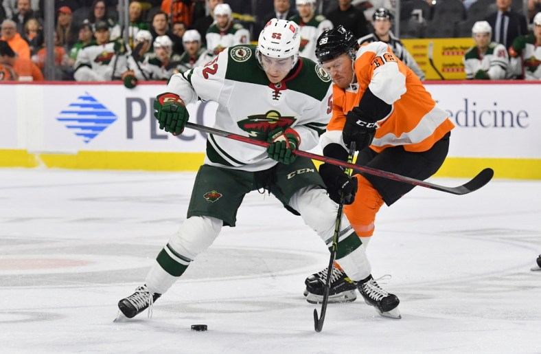 Mar 3, 2022; Philadelphia, Pennsylvania, USA; Minnesota Wild center Connor Dewar (52) and Philadelphia Flyers center Patrick Brown (38) battle for the puck during the first period at Wells Fargo Center. Mandatory Credit: Eric Hartline-USA TODAY Sports