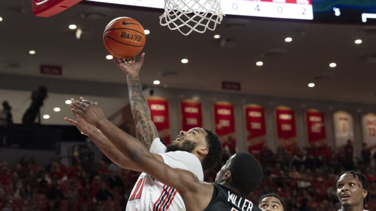 Mar 3, 2022; Houston, Texas, USA;  Houston Cougars guard Kyler Edwards (11) shoots against Temple Owls guard Hysier Miller (4) in the first half at Fertitta Center. Mandatory Credit: Thomas Shea-USA TODAY Sports