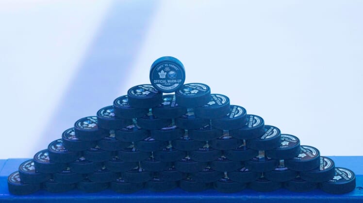 Mar 2, 2022; Toronto, Ontario, CAN; The official warmup pucks sit on the boards prior to the warmup between the Toronto Maple Leafs and Buffalo Sabres at Scotiabank Arena. Mandatory Credit: Nick Turchiaro-USA TODAY Sports