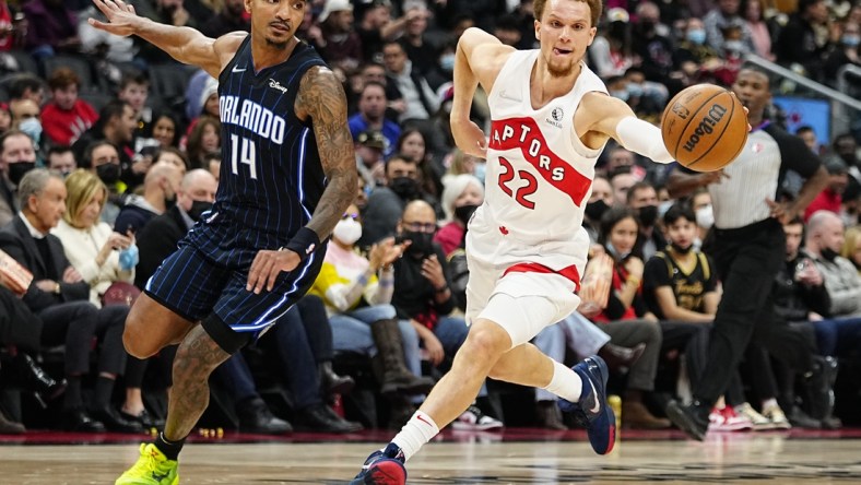 Mar 4, 2022; Toronto, Ontario, CAN; Toronto Raptors guard Malachi Flynn (22) drives to the basket against Orlando Magic guard Gary Harris (14) during the first half at Scotiabank Arena. Mandatory Credit: John E. Sokolowski-USA TODAY Sports