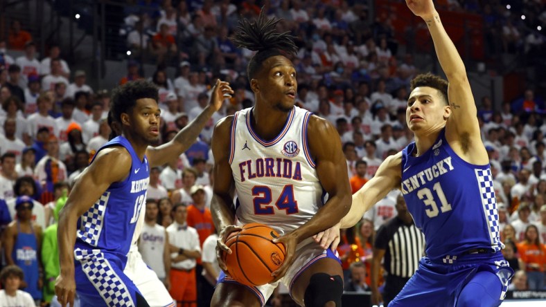 Mar 5, 2022; Gainesville, Florida, USA; Florida Gators guard Phlandrous Fleming Jr. (24) drives to the basket as Kentucky Wildcats forward Keion Brooks Jr. (12) and guard Kellan Grady (31) defend during the first half at Billy Donovan Court at Exactech Arena. Mandatory Credit: Kim Klement-USA TODAY Sports