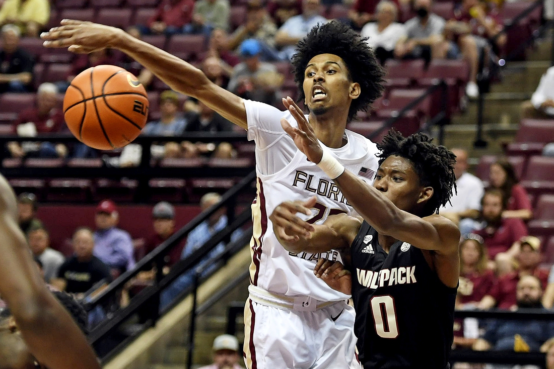 Mar 5, 2022; Tallahassee, Florida, USA; Florida State Seminoles forward John Butler (22) fights for a loose ball with North Carolina State Wolfpack guard Terquavion Smith (0) during the first half at Donald L. Tucker Center. Mandatory Credit: Melina Myers-USA TODAY Sports