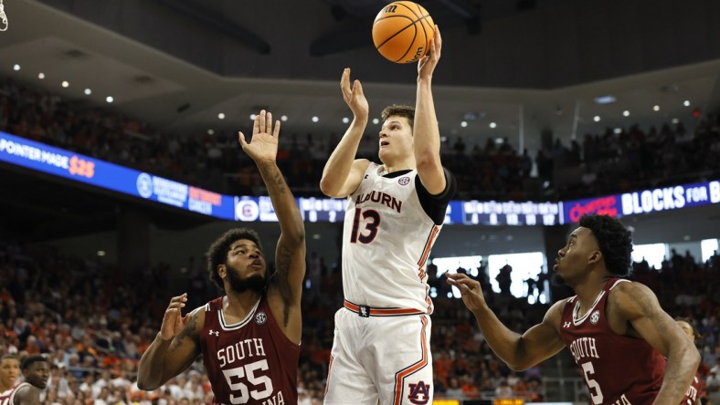 Mar 5, 2022; Auburn, Alabama, USA; Auburn Tigers forward Walker Kessler (13) shoots between South Carolina Gamecocks forward Ta'Quan Woodley (55) and guard Jermaine Couisnard (5) during the second half at Neville Arena. Mandatory Credit: John Reed-USA TODAY Sports