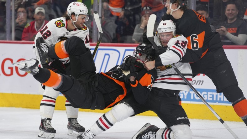 Mar 5, 2022; Philadelphia, Pennsylvania, USA; Chicago Blackhawks center Jonathan Toews (19) pulls Philadelphia Flyers defenseman Rasmus Ristolainen (70) to the ice in the second period at the Wells Fargo Center. Mandatory Credit: Mitchell Leff-USA TODAY Sports