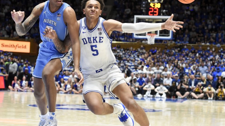 Mar 5, 2022; Durham, North Carolina, USA; Duke Blue Devils forward Paolo Banchero (5) loses the ball out of bounds as he drives to the basket with North Carolina Tar Heels forward Armando Bacot (5) defending during the second half  at Cameron Indoor Stadium.  The Tar Heels won 94-81. Mandatory Credit: Rob Kinnan-USA TODAY Sports