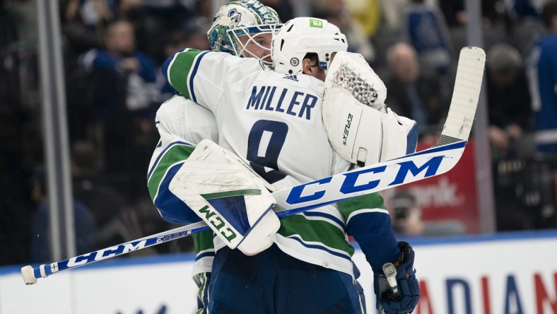 Mar 5, 2022; Toronto, Ontario, CAN; Vancouver Canucks goaltender Thatcher Demko (35) celebrates the win with center J.T. Miller (9) at the end of the third period against the Toronto Maple Leafs at Scotiabank Arena. Mandatory Credit: Nick Turchiaro-USA TODAY Sports