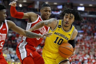 Mar 6, 2022; Columbus, Ohio, USA;  Michigan Wolverines guard Frankie Collins (10) looks for the shot as Ohio State Buckeyes guard Eugene Brown III (3) and guard Jamari Wheeler (55) defend during the first half at Value City Arena. Mandatory Credit: Joseph Maiorana-USA TODAY Sports