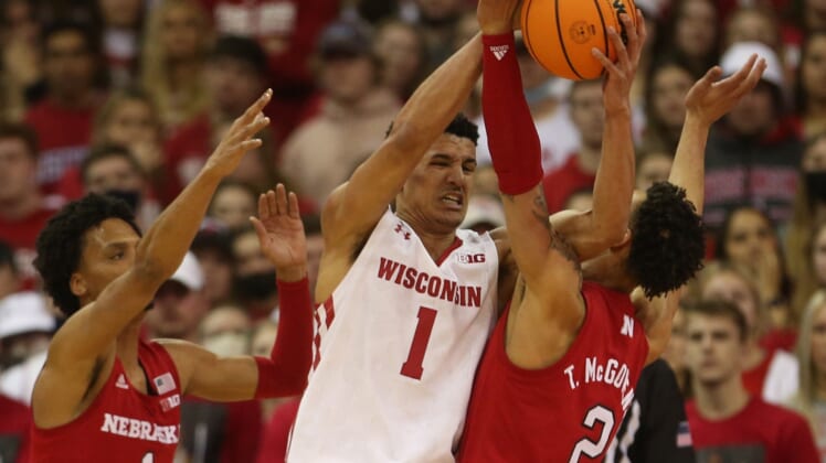 Mar 6, 2022; Madison, Wisconsin, USA; Wisconsin Badgers guard Johnny Davis (1) looks to pass as Nebraska Cornhuskers guard Alonzo Verge Jr. (1) and guard Trey McGowens (2) defend at the Kohl Center. Mandatory Credit: Mary Langenfeld-USA TODAY Sports