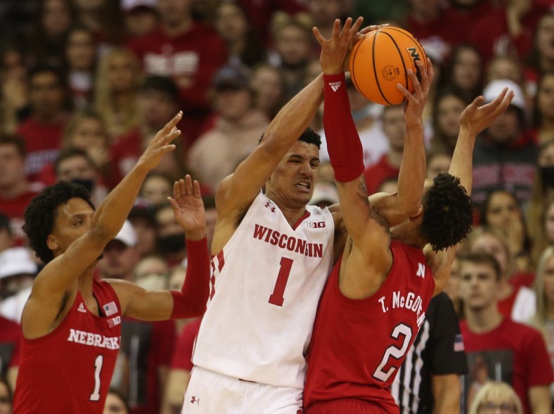 Mar 6, 2022; Madison, Wisconsin, USA; Wisconsin Badgers guard Johnny Davis (1) looks to pass as Nebraska Cornhuskers guard Alonzo Verge Jr. (1) and guard Trey McGowens (2) defend at the Kohl Center. Mandatory Credit: Mary Langenfeld-USA TODAY Sports