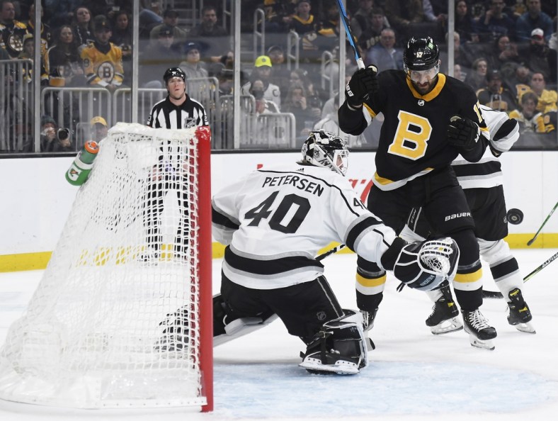 Mar 7, 2022; Boston, Massachusetts, USA;  Boston Bruins left wing Nick Foligno (17) eyes the puck as it goes past Los Angeles Kings goaltender Cal Petersen (40) during the first period at TD Garden. Mandatory Credit: Bob DeChiara-USA TODAY Sports