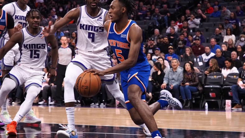 Mar 7, 2022; Sacramento, California, USA; New York Knicks guard Immanuel Quickley (5) drives along the baseline against Sacramento Kings guard Davion Mitchell (15) and guard Justin Holiday (9) during the second quarter at Golden 1 Center. Mandatory Credit: Kelley L Cox-USA TODAY Sports