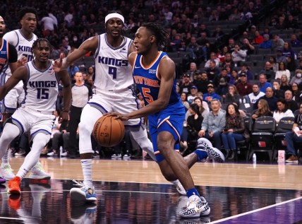Mar 7, 2022; Sacramento, California, USA; New York Knicks guard Immanuel Quickley (5) drives along the baseline against Sacramento Kings guard Davion Mitchell (15) and guard Justin Holiday (9) during the second quarter at Golden 1 Center. Mandatory Credit: Kelley L Cox-USA TODAY Sports