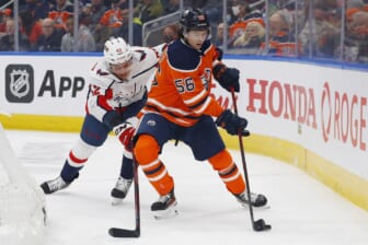 Mar 9, 2022; Edmonton, Alberta, CAN; Edmonton Oilers forward Kailer Yamamoto (56) and Washington Capitals defensemen Martin Fehervary (42) battle along the boards for a loose puck during the first period at Rogers Place. Mandatory Credit: Perry Nelson-USA TODAY Sports