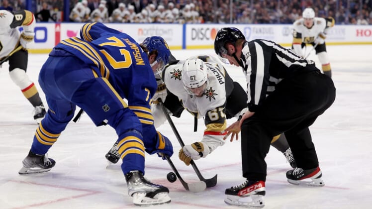 Mar 10, 2022; Buffalo, New York, USA;  NHL linesman Tyson Baker (88) drops the puck for a face-off between Buffalo Sabres right wing Tage Thompson (72) and Vegas Golden Knights left wing Max Pacioretty (67) during the first period at KeyBank Center. Mandatory Credit: Timothy T. Ludwig-USA TODAY Sports