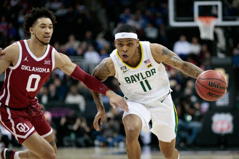 Mar 10, 2022; Kansas City, MO, USA; Baylor Bears guard James Akinjo (11) drives to the basket around Oklahoma Sooners guard Jordan Goldwire (0) during the first half at T-Mobile Center. Mandatory Credit: William Purnell-USA TODAY Sports