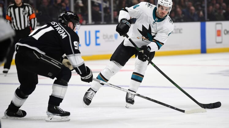 Mar 10, 2022; Los Angeles, California, USA; San Jose Sharks defenseman Jaycob Megna (24) moves the puck against Los Angeles Kings right wing Carl Grundstrom (91) during the first period at Crypto.com Arena. Mandatory Credit: Gary A. Vasquez-USA TODAY Sports
