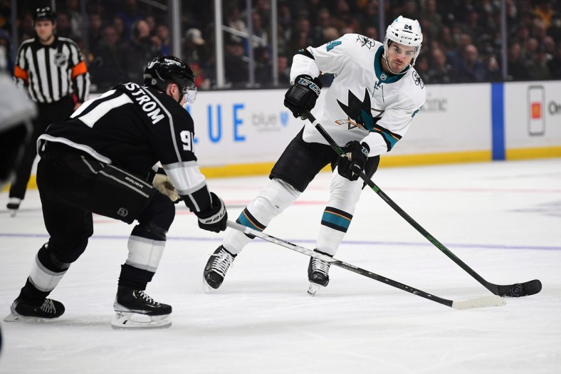 Mar 10, 2022; Los Angeles, California, USA; San Jose Sharks defenseman Jaycob Megna (24) moves the puck against Los Angeles Kings right wing Carl Grundstrom (91) during the first period at Crypto.com Arena. Mandatory Credit: Gary A. Vasquez-USA TODAY Sports