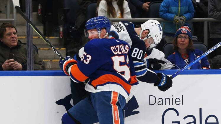 Mar 11, 2022; Elmont, New York, USA; New York Islanders center Casey Cizikas (53) and Winnipeg Jets left wing Pierre-Luc Dubois (80) collide at the boards during the first period at UBS Arena. Mandatory Credit: Andy Marlin-USA TODAY Sports