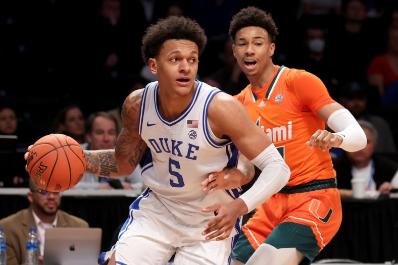 Mar 11, 2022; Brooklyn, NY, USA; Duke Blue Devils forward Paolo Banchero (5) controls the ball against Miami Hurricanes guard Jordan Miller (11) during the first half of the ACC Tournament semifinal game at Barclays Center. Mandatory Credit: Brad Penner-USA TODAY Sports