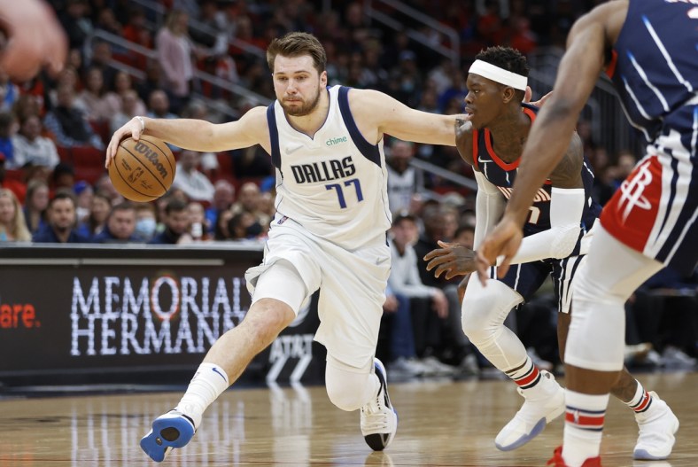 Mar 11, 2022; Houston, Texas, USA; Dallas Mavericks guard Luka Doncic (77) drives with the ball as Houston Rockets guard Dennis Schroder (17) defends during the third quarter at Toyota Center. Mandatory Credit: Troy Taormina-USA TODAY Sports
