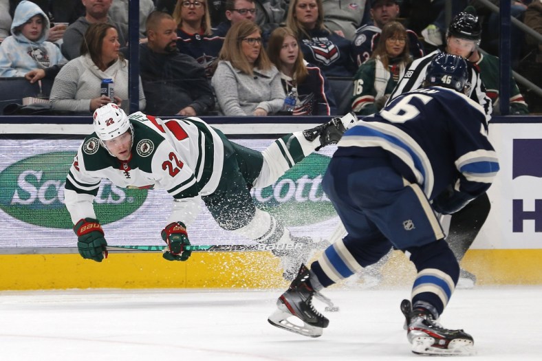 Mar 11, 2022; Columbus, Ohio, USA; Minnesota Wild left wing Kevin Fiala (22) falls to the ice after colliding with an official during the third period against the Columbus Blue Jackets at Nationwide Arena. Mandatory Credit: Russell LaBounty-USA TODAY Sports