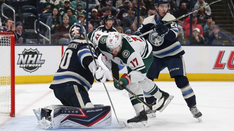 Mar 11, 2022; Columbus, Ohio, USA; Minnesota Wild left wing Marcus Foligno (17) collides with Columbus Blue Jackets goalie Elvis Merzlikins (90) during the third period at Nationwide Arena. Mandatory Credit: Russell LaBounty-USA TODAY Sports