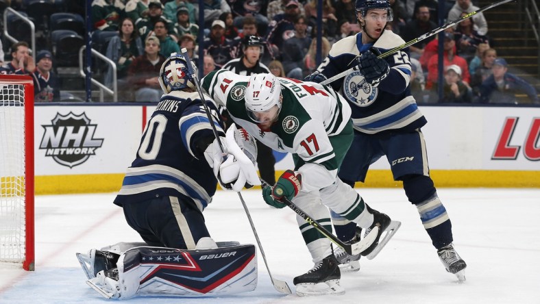 Mar 11, 2022; Columbus, Ohio, USA; Minnesota Wild left wing Marcus Foligno (17) collides with Columbus Blue Jackets goalie Elvis Merzlikins (90) during the third period at Nationwide Arena. Mandatory Credit: Russell LaBounty-USA TODAY Sports