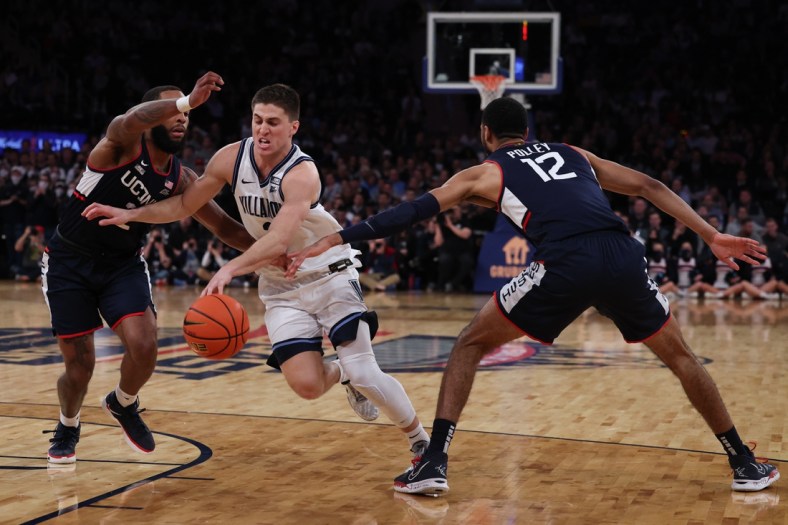 Mar 11, 2022; New York, NY, USA; Villanova Wildcats guard Collin Gillespie (2) drives to the basket as Connecticut Huskies guard R.J. Cole (2) and forward Tyler Polley (12) defend during the second half at Madison Square Garden. Mandatory Credit: Vincent Carchietta-USA TODAY Sports