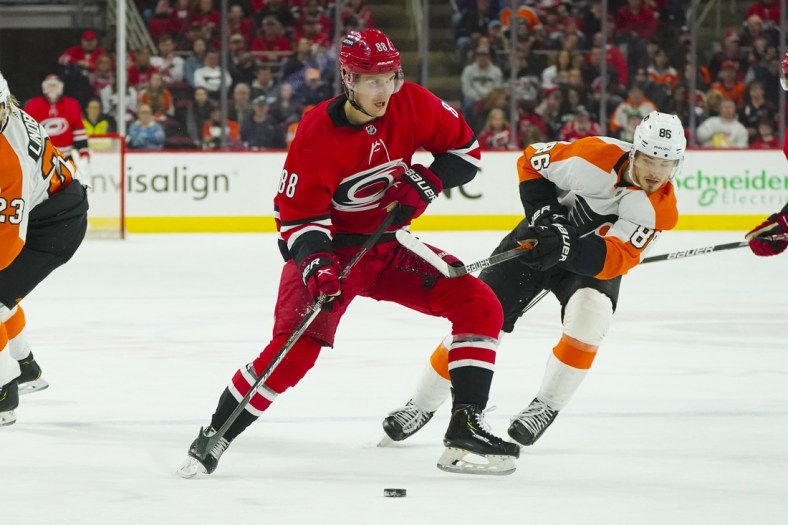 Mar 12, 2022; Raleigh, North Carolina, USA;  Carolina Hurricanes center Martin Necas (88) skates with the puck past Philadelphia Flyers left wing Joel Farabee (86) during the first period at PNC Arena. Mandatory Credit: James Guillory-USA TODAY Sports