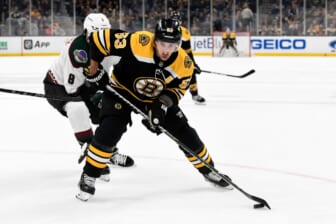 Mar 12, 2022; Boston, Massachusetts, USA; Boston Bruins left wing Brad Marchand (63) controls the puck in front of Arizona Coyotes center Nick Schmaltz (8) during the first period at the TD Garden. Mandatory Credit: Brian Fluharty-USA TODAY Sports