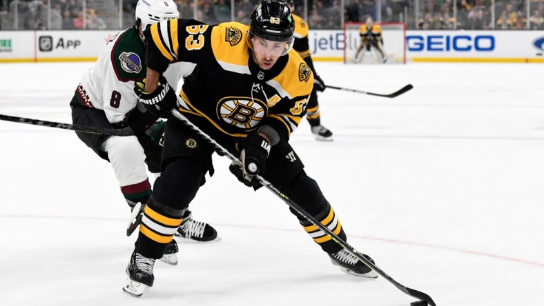 Mar 12, 2022; Boston, Massachusetts, USA; Boston Bruins left wing Brad Marchand (63) controls the puck in front of Arizona Coyotes center Nick Schmaltz (8) during the first period at the TD Garden. Mandatory Credit: Brian Fluharty-USA TODAY Sports